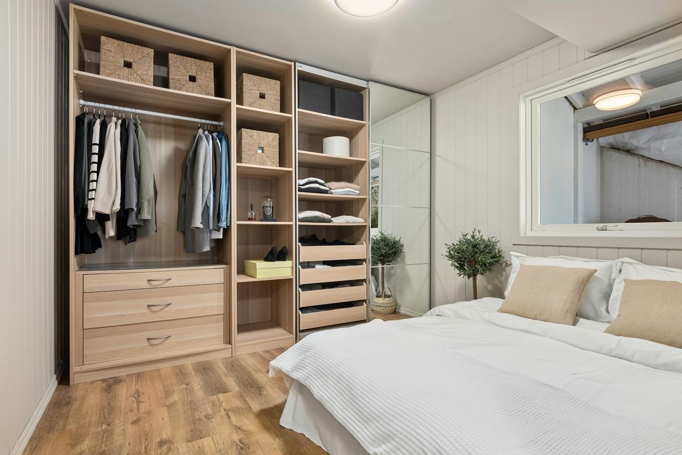 Mirrored sliding wardrobe doors reflecting the light across a bedroom